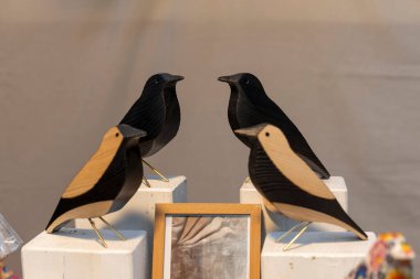 Flea market sale. Wooden figurines of starlings or crows as home decor. clipart