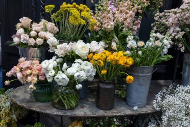 Beyaz güller, ranunculus, pembe güller, sarı altın toplar, beyaz papatyalar, vazolarda restoran, kafe ve çiçekçi dekoru..