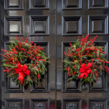 Two wreaths made of fir or spruce branches with red bows and red berries. clipart