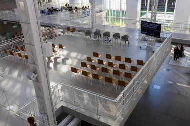 Moskova, Rusya - 20 Ağustos 2024, GES-2 Kültür Evi. Sıra sıra sandalyelerle konferans salonu. Pencerelerdeki sandalyelerin gölgeleri.