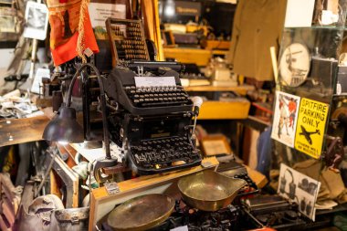 Warsaw, Poland - September 2, 2024, Antique store and flea market of antique items in the old town. An old typewriter and scales for sale. clipart