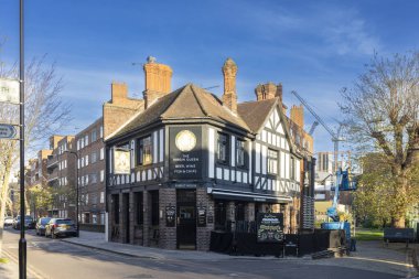 Londra, İngiltere - 2 Aralık 2024. Bakire Kraliçe, mavi gökyüzünün arka planına karşı küçük bir bar..