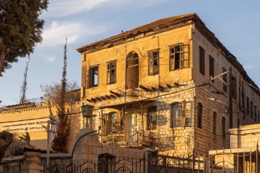 Nasıra, İsrail, 23 Ocak 2025, ahşap panjurları ve fayanslı çatısı olan terk edilmiş iki katlı eski bir ev..