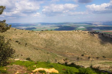 Gilboa Dağı 'nın manzarası çamları, bitki örtüsünü, vadiyi ve Ürdün dağlarını yukarıdaki bulutları ve aşağıdaki tarlaları kapsıyor..