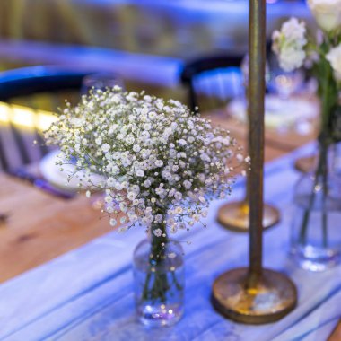Bar mitzvah masası seti, lisianthus buketleri ve jigolo, ayrıca bir düğün etkinliği için gazyağı lambaları..