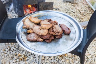 Sokakta bir tencerede kızartılmış et tepside.