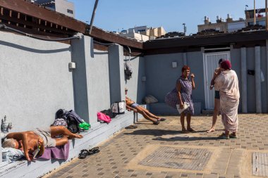 Hayfa, İsrail, 14 Mart 2025. Yaşlı insanlar güneşleniyor, Yarasa Galim Sahili 'ndeki banklarda yatıyor..