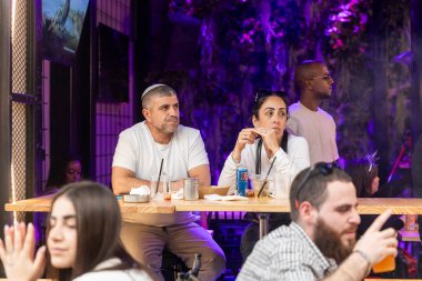 Kudüs, İsrail, 16 Mart 2025. Bir erkek ve bir kadın Mahane Yehuda Market 'te bir kafede oturmuş kokteyl içiyorlar.