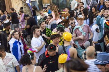 Kudüs, İsrail, 16 Mart 2025, Purim kutlamalarında kalabalık içinde dans eden kippah ve şapkalı gençler..