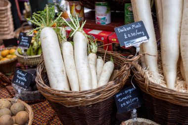 Londra, Borough pazarı, İngiltere, 23 Kasım 2024, Taze Daikon turpları ve diğer sebzeler bir pazarda satılıyor.