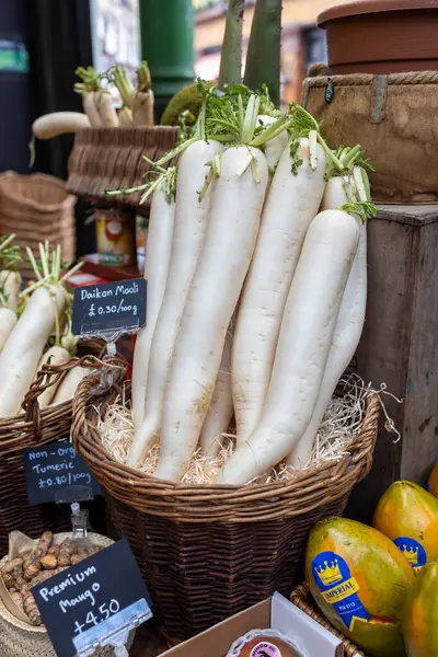 Londra, Borough pazarı, İngiltere, 23 Kasım 2024, Fresh Daikon turpları bir markette fiyat etiketleri ile bir sepette