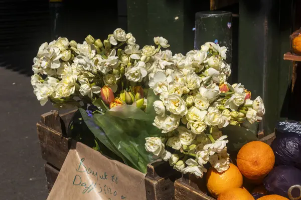 Karpuzlar ve beyaz nergisler bir marketin ahşap kasalarında