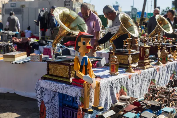 Hayfa, İsrail, 2 Ocak 2025, Pinokyo kuklası ve klasik gramofonlar açık hava pazarında satılıyor. İnsanlar alışveriş yapıyor.