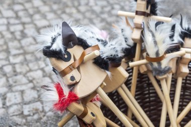 Yün yeleleri ve kuyrukları açık hava pazarında satılık ahşap atlar.