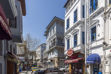 İstanbul, Türkiye, 2 Mayıs 2024, Arnavut bölgesi sokak manzaralı renkli binalar, kafeler, dükkanlar ve yanından geçen insanlar.