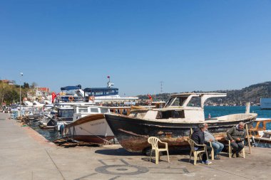 İstanbul, Türkiye, 2 Mayıs 2024, İstanbul 'un Bebek kentinde teknelerinin yanında oturan balıkçılar, İstanbul Boğazı manzaralı.