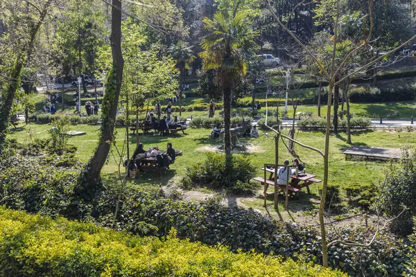 İstanbul, Türkiye, 2 Mayıs 2024, Emirgan Park, İstanbul 'daki piknik masalarında dinlenen insanlar, yemyeşil alanlarla çevrili.