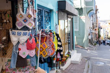 İstanbul, Türkiye, 2 Mayıs 2024, İstanbul 'un Balat ilçesindeki renkli bir mağazanın önünde el yapımı tığ işi giysiler satışa sunuldu, 