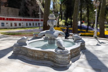 İstanbul, Türkiye, 2 Mayıs 2024, Gülhane Parkı 'ndaki süslü mermer çeşme yürüyüş yolları, ağaçlar ve manzaranın keyfini çıkaran insanlarla çevrili..