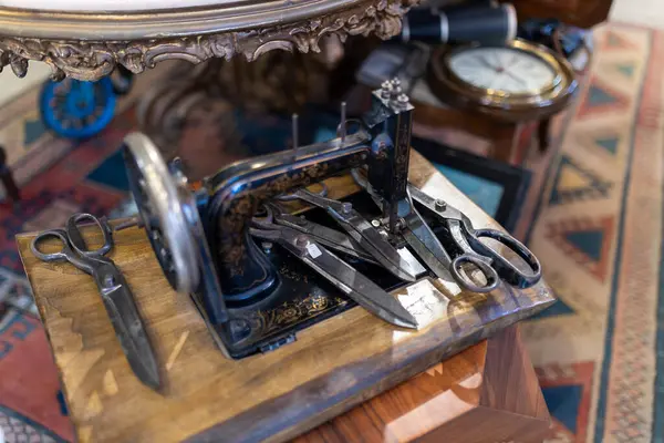 İstanbul, Türkiye, 2 Mayıs 2024, Vintage Singer 221 Tüy sıklet dikiş makinesi, çeşitli makas ve antika eşyalar ile çevrelenmiş, muhtemelen bit pazarındaki bir dükkan veya antikacıda sergilenmektedir.