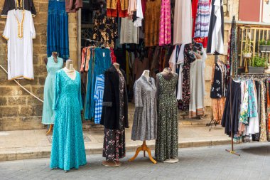 Tel Aviv-Jaffa, İsrail, 9 Nisan 2025, eski Jaffa 'daki bir dükkanın önünde renkli kadın kıyafetleri sergileniyor.