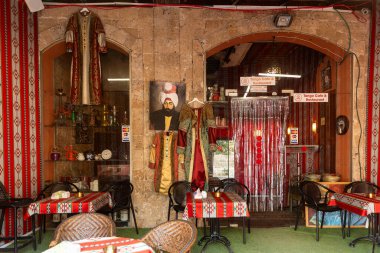 Tel Aviv-Jaffa, İsrail. 9 Nisan 2025, Jaffa 'da sergilenen geleneksel Ortadoğu tarzı Tango Kafe, renkli tekstil, hookahs ve Osmanlı giysileri,