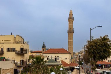 Tel Aviv-Jaffa, İsrail. 9 Nisan 2025, Al bahar Camii. Tel Aviv 'in tarihi eski jaffa bölgesinin şehir manzarası karakteristik taş binaları ve bulutlu bir gökyüzünün altında göze çarpan minaresi..