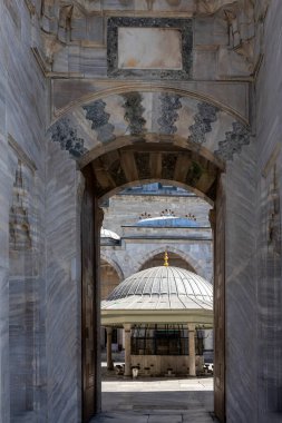İstanbul, Türkiye, 5 Nisan 2024, Fatih ilçesindeki Yavuz Selim Camii 'nin (Selim I Camii) avlusuna açılan kemerli mermer giriş Cami çeşmesi ve kubbeleri 