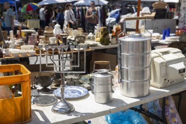 Hayfa, İsrail, 16 Nisan 2025, Hayfa, İsrail 'de açık hava pazarında bir masanın yakın çekimi, bir menora, metal kaplar ve seramik de dahil olmak üzere çeşitli ürünleri sergileniyor.