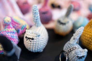 Kapalı çekimde birkaç küçük, tığ işi kedi anahtarlığı ve muhtemelen satılık anlamlı yüzler.