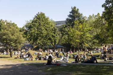 Londra, İngiltere, 10 Mayıs 2025 İnsanlar rahatlar ve Londra 'daki park alanlarında güneşin tadını çıkarırlar.