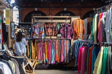Londra, İngiltere, 10 Mayıs 2025 'te Spitalfields Market' teki Brick Lane Market 'te renkli giysiler sergileniyor.,