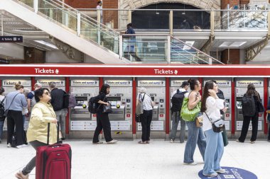 Londra, İngiltere, 10 Mayıs 2025, Yolcular Liverpool Caddesi İstasyonu 'ndaki makinelerden bilet alıyorlar