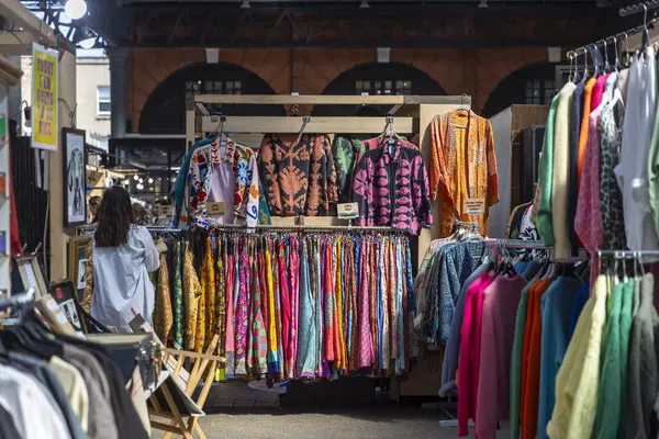 Londra, İngiltere, 10 Mayıs 2025 'te Spitalfields Market' teki Brick Lane Market 'te renkli giysiler sergileniyor.,