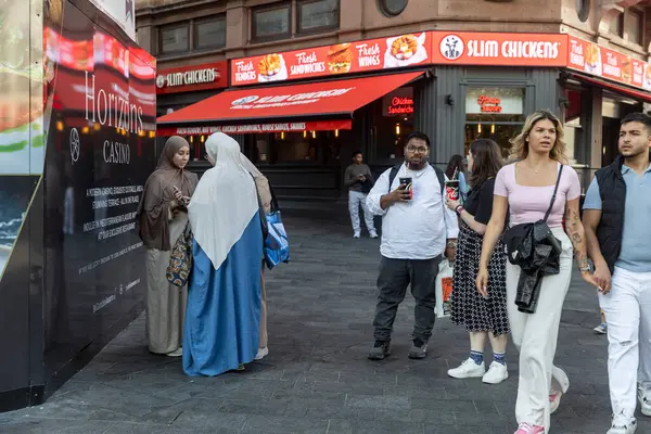 Londra, İngiltere, 10 Mayıs 2025 İnsanlar Slim Chickens restoranının ve Horizons Kumarhanesinin önünden geçiyor. 