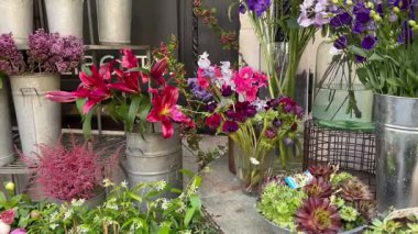 Londra, İngiltere - 5 Mayıs 2025, Bir buket kırmızı zambak, şakayık ve okaliptüs Liberty mağazasının girişini süslüyor.