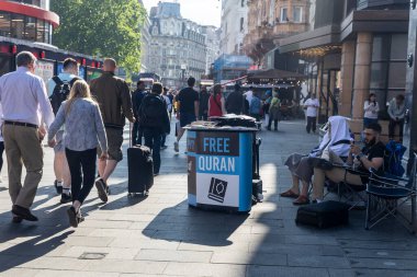 Özgür Kur 'an standının önünden geçen ve Londra caddesinde dinlenen insanlar.