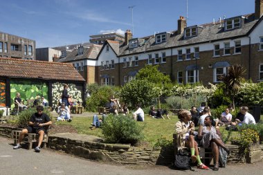 Londra, İngiltere, 10 Mayıs 2025, Londra 'da güneşli bir günde Halk Bahçesinde Rahatlayan İnsanlar