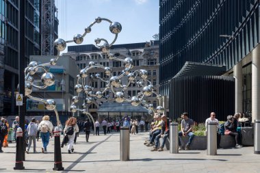 Londra, İngiltere, 15 Mayıs 2025, İnsanlar bir şehirde modern bir heykelin yanında yürüyor ve oturuyorlar. Sonsuz Birikim: Yayoi Kusama
