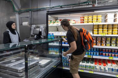 Baqa al Gharbiya, İsrail, 22 Mayıs 2025, dondurulmuş bir süpermarkette mandıra ve turşu ürünleri, buzdolabından seçen bir müşteri,.