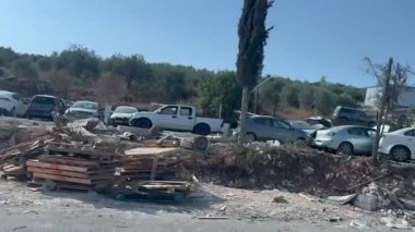 Bartaa, Filistin Yönetimi, 22 Mayıs 2025. Reyhan kontrol noktasına giden yol. Eski arabalar parçalara ayrılır. Yerel bir iş. Yol boyunca araba cesetleri..