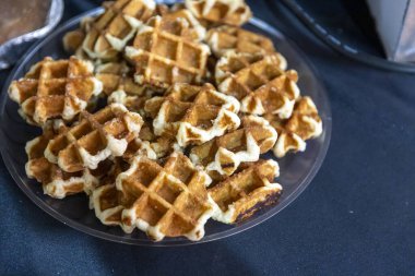 Mavi masadaki Altın Kahverengi Belçika Waffle tabağı.