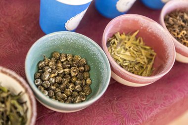 Kırmızı masa örtüsü üzerinde gevşek yaprak çayları.