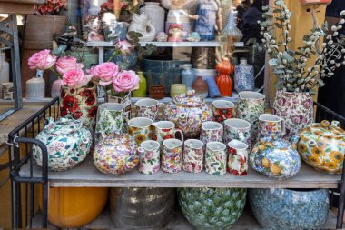 Londra, İngiltere, 5 Mayıs 2025, renkli seramik çaydanlıklar ve kupalar bir pazarda sergileniyor.