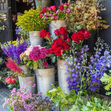Dükkanın dışındaki metal kovalarda taze kesilmiş çiçekler..