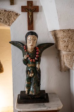 Jaffa, Tel Aviv, İsrail, 22 Mayıs 2025, arka planda haç olan eski, ahşap bir melek heykeli. Ilana Goor Müzesi içinde..