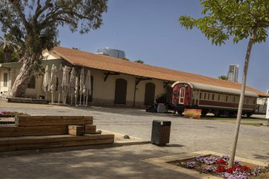 Tel Aviv, İsrail, 22 Mayıs 2025 eski bir tren vagonu ve Tel Aviv 'deki Eski Tren İstasyonu' nda turuncu çatılı bir bina..