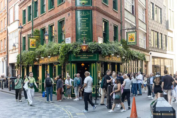 Londra, İngiltere, 5 Mayıs 2025, Londra 'daki Devonshire Pub. Barın etrafında bira içen bir kalabalık.