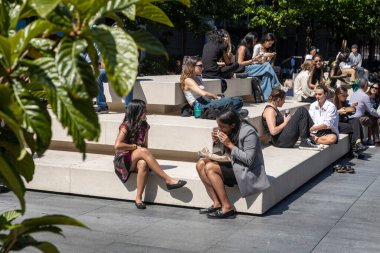 Londra, İngiltere, 5 Mayıs 2025, Güneşli Şehir Meydanında İnsanlar Oturuyor ve Rahatlıyor