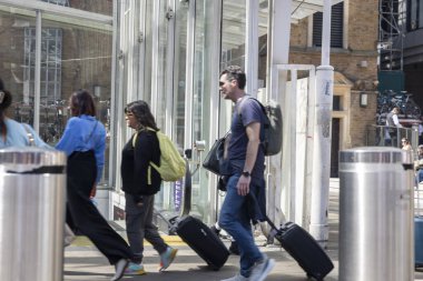 Londra, İngiltere, 7 Mayıs 2025, People 's Walking with Bavulside a Modern Building. Bulanık kavram